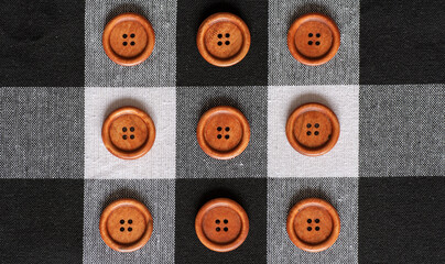 Round wooden brown sewing buttons isolated on textile background.  Top view . Close up. Macro.