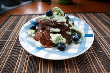 Homemade pancakes with blueberries and ice cream. Plate with blue paint strokes