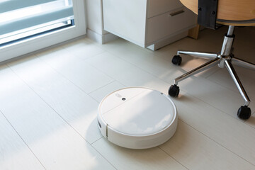 Robotic vacuum cleaner hoovering the floor at home
