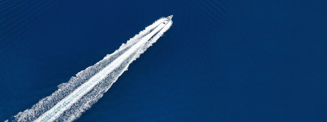 Aerial drone ultra wide photo of speed boat cruising fast in deep blue Aegean Sea