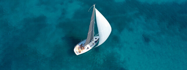 Aerial drone ultra wide photo of beautiful sail boat cruising tropical exotic bay with turquoise sea