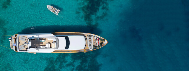 Aerial drone ultra wide top down photo of luxury yacht anchored in tropical exotic bay with emerald...