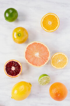 Various citrus fruits on marble counter