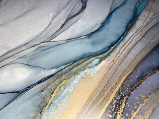 Abstract blue and grey background with beautiful smudges and stains made with alcohol ink and gold...