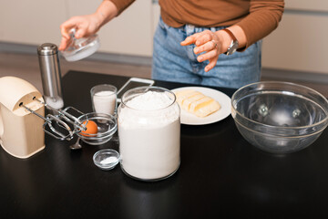Womans hands are preparing all ingredients for some gingerbread dough.