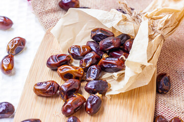 Sweet dried dates on light  wooden background in the kitchen.