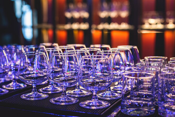 Line of alcohol setting on catering banquet table, bartender pouring beverages, row of different colored alcohol cocktails on a party, martini, vodka, and others on decorated banquet table event