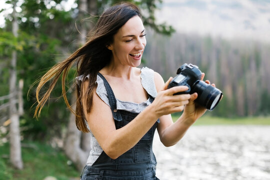 Woman taking pictures by lake