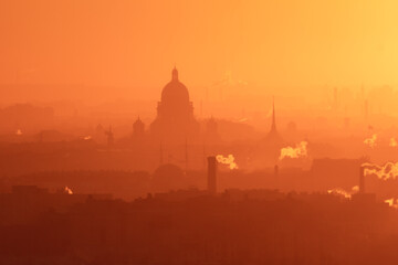 Naklejka premium Aerial panoramic view of Saint-Petersburg, Russia, with St. Isaac's cathedral, the Winter Palace and Admiralty, with beautiful vibrant red orange sunset sundown, dusk cityscape silhouette scenery