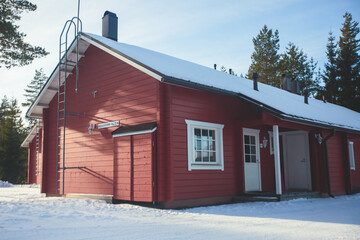 A view of cozy wooden scandinavian cabin cottage chalet house covered in snow near ski resort in...