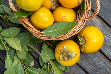top view fresh persimmons inside basket on wooden desk fruits mellow ripe tree