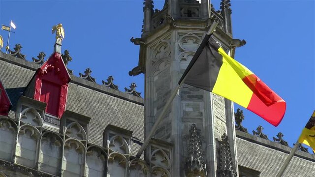 Flag of Belgium waving on the roof of the Provincial Court building in Bruges.