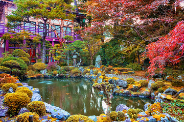 Japan Travel Concepts. Traditional japanese Garden with Red Maples, Pond and Stone Lanterns on...