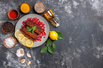 Fototapeta na wymiar top view tasty meat cutlets with seasonings on the grey background meal food dish