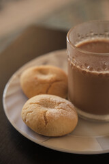 Cookies and coffee in a white plate. Coffee with milk in glass cup. Homemade cookies.
