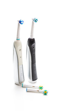 Pair of Professional Electric Toothbrushes With Spare Attachments Placed Together on White Background.