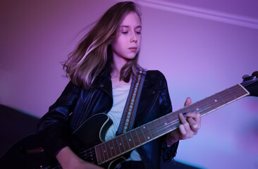 Obraz premium Girl playing on the semi-acoustic guitar at home party.