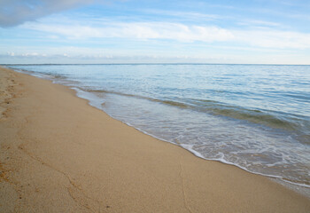 Fototapeta na wymiar horizontal background of gentle waves on a golden sandy tropical beach