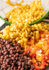 Corn, black beans and bell peppers being prepared for a meal.