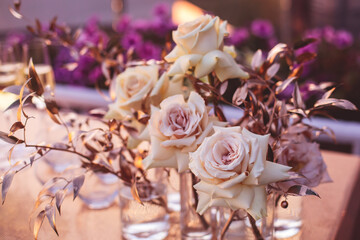Beautiful wedding ceremony interior and table decor, flower decoration with flowers bouquet, with roses, tulips, peonies in pink and golden color tones