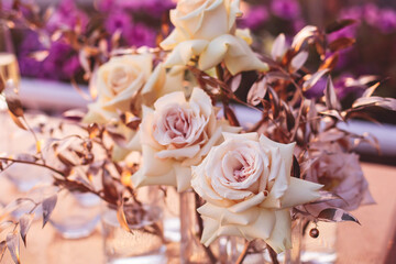 Beautiful wedding ceremony interior and table decor, flower decoration with flowers bouquet, with roses, tulips, peonies in pink and golden color tones