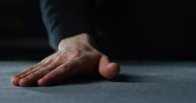 Cinematic macro shot of experienced tailor is touching with his hand fine quality fabric for creation custom haute couture apparel in tailoring atelier. Concept of handmade, couturier and tradition.