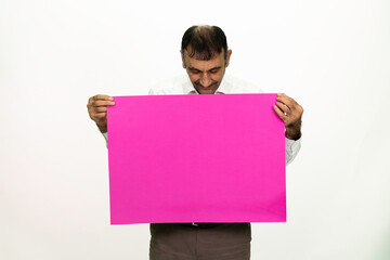 Man holding a purple banner in his hand. It can be written on. She is dressed in a white shirt and fabric pants. Isolated image white background.