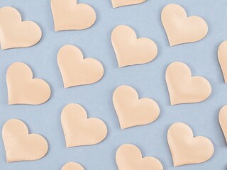 Background with hearts on gray.

Background with hearts of champagne color arranged diagonally on gray, top view close-up.