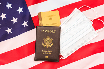 American passport with vaccination record on a flag.