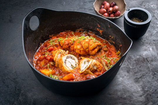 Modern Style traditionelle slow cooked italienische Rouladen Saltimbocca vom Kalb mit Gemüse und Olives in würziger Bratensauce als close-up in einem Design Topf