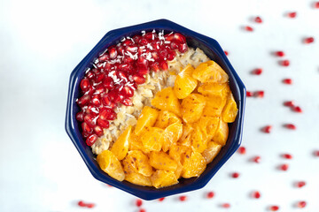 Close up of porridge with pomegranate seeds and mandarins. Healthy meal. Change in diet.