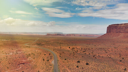 Fototapeta na wymiar Countryside road through the fabulous Monument Valley in summser season, aerial view from drone