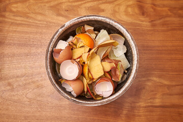 Domestic Peeled Apples, Eggs & Onions In A Ceramic Pot On A Raw Wooden Table Waiting To Be Composted