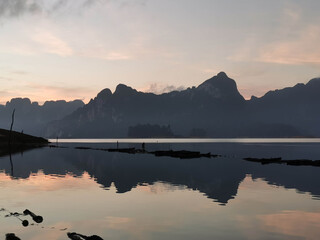 sun over a mountain on a lake in thailand, but it's grey
