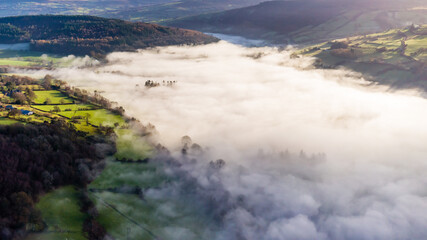 Aerial view of a beautiful rural valley filled with a blanket of thick fog