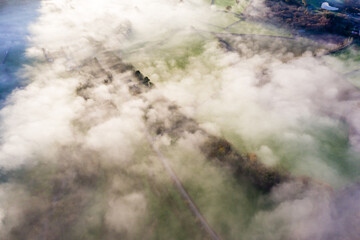 Aerial view looking down onto a trees in a beautiful, rural fog filled valley (Mid Wales)