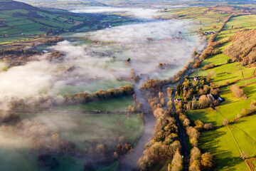 Aerial view of patches of fog along a river in a rural setting (River Usk, Wales)