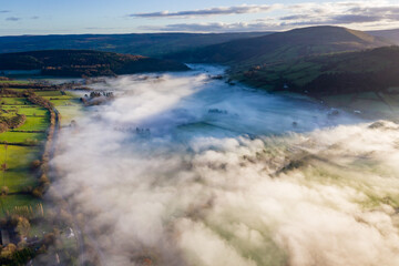 Aerial view of a beautiful rural valley filled with a blanket of thick fog