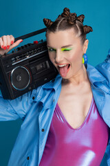 Obraz na płótnie Canvas Beautiful smiling girl with stylish hair and makeup holds boombox