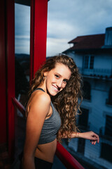 Fototapeta na wymiar Young caucasian girl at the balcony