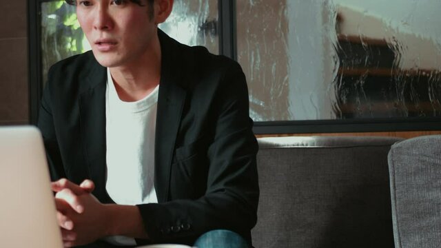 リビングのソファでテレワークをする男性