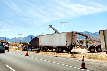 Fototapeta na wymiar Removing a semi truck and trailer from a ditch with cranes