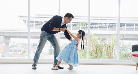 Father is teaching his little daughter to dance in the halls of the house. Happy holidays, family relationships.