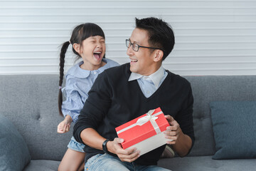 Celebrate father days. Little girl is giving her father a gift box. Children daughters...