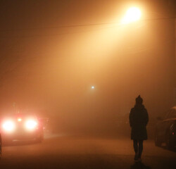 Fototapeta premium Thick fog in the night, lonely woman walking on the street.