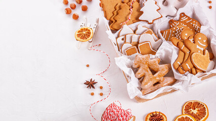 Top view of unpacked christmas present with sweets on a white textured surface, close-up. Christmas celebration concept with space for text