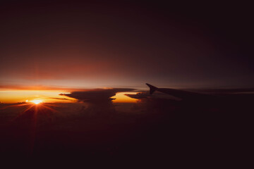Airplane wing against sunset sky background.