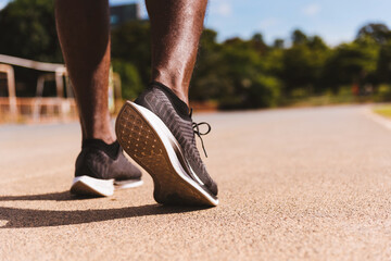Asian young athlete sport runner black man wear feet active ready to running training at the outdoor on the treadmill line road for a step forward, healthy exercise workout, closeup back shoe