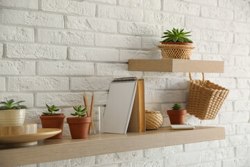 Fototapeta na wymiar Shelves with decorative elements on white brick wall. Interior design