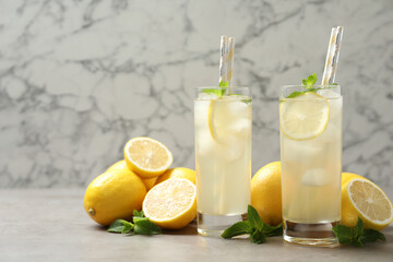 Natural lemonade with mint and fresh fruits on light grey table. Summer refreshing drink